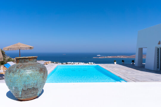 Infinity pool with azure water. an earthenware jar in the foreground. Luxury lifestyle, Paros,