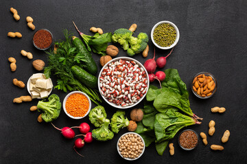  A source of protein for vegetarians: vegetables, nuts, seeds and legumes top view on a black background. Concept: Purchase healthy clean food.