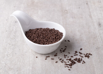 Dark chocolate sprinkles in a white bowl. Typical brazilian brigadeiro topping