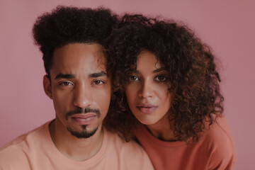 Close-up of young African American man, woman staring seriously at camera indoors. Wide photo well-groomed guy with beard and pretty girl clean and soft skin. Facial care concept
