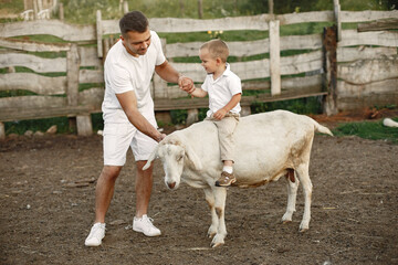 Family spending time together outside with a goat