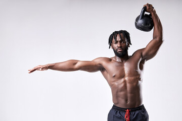 African american shirtless man lifting up kettlebell isolated on white studio background. Black...