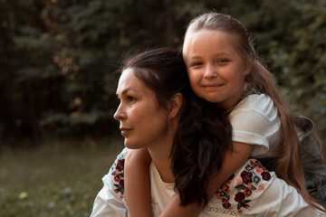 mother and daughter hugging in park or forest