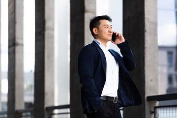 Asian businessman talking on the phone serious has an angry conversation