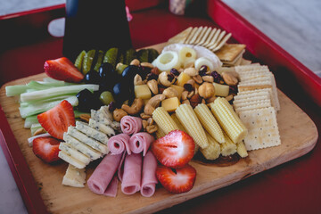Tray with a table with pickles, celery, strawberries, olives, cheese, hearts of palm, cookies, nuts and ham