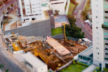 Tilt shift of a construction work near a building.