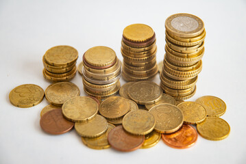 Stacks of euro coins placed on white surface. Money and value of money.
