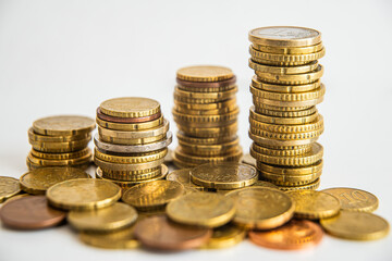 Stacks of euro coins placed on white surface. Money and value of money.
