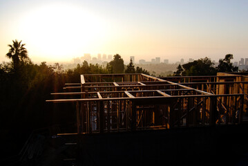 Obraz premium First sunlight over a construction site with structural wood framing