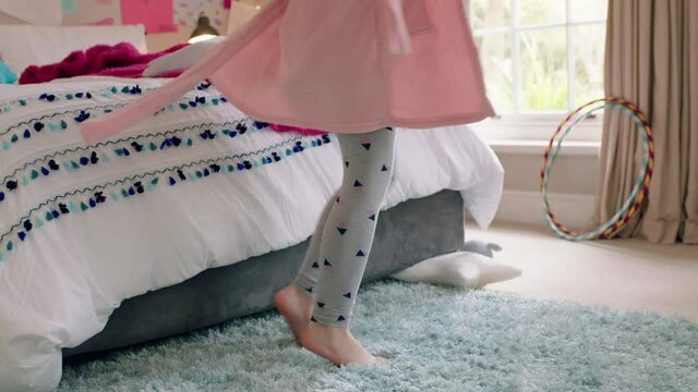 happy little girl dancing in bedroom having fun playful morning wearing pajamas enjoying weekend at home