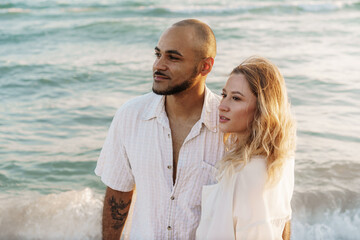 Young happy couple on seashore enjoying the sea