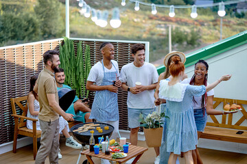 Group of diverse friends making barbecue in the backyard, having good and positive emotions,...