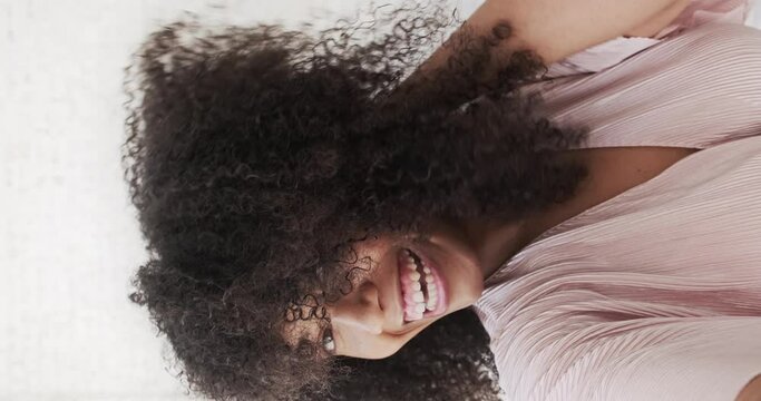 Vertical video pov. Trendy happy mixed woman vlogger dances and recording videostream video for social media. Enjoyed female taking selfies using smartphone. Creating dancing video using tiktok app.