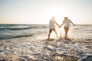 Young beautiful couple walking on beach near sea