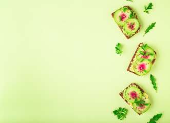 Fototapeta na wymiar Toasts with watemelon radish, avocado and flex seeds
