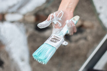 hand holding brush with paint