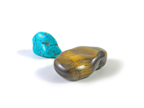 Tigers eye an turquoise stone on white background