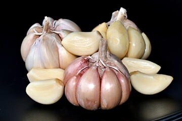 garlic on a black background with heads of garlic