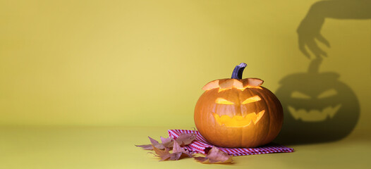 Carved Halloween pumpkin on yellow background