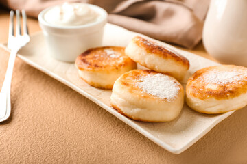 Plate with tasty cottage cheese pancakes on table