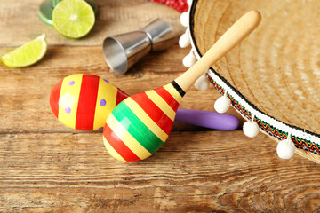 Mexican maracas, tequila and sombrero on wooden background