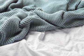 Knitted plaid on bed, closeup