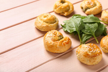 Puff pastry stuffed with spinach on color wooden background