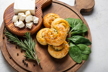 Puff pastry stuffed with spinach, feta cheese and herbs on light background