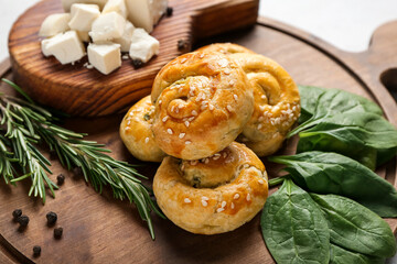 Puff pastry stuffed with spinach, feta cheese and herbs on wooden background