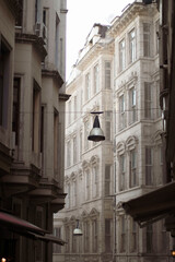 Fototapeta na wymiar An old lantern hangs between houses on an old street in Istanbul 