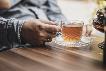 man drinking tea from a transparent glass cup 