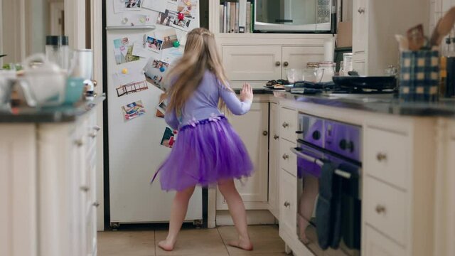 happy ballerina girl dancing in kitchen wearing purple tutu having fun performing funny dance moves enjoying weekend celebration at home