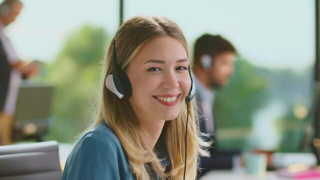 Close up portrait of a customer support operator, Call center smiling operator with phone headset looking at the camera.