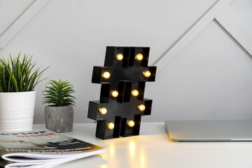 Stylish lamp on table near light wall