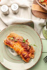 Plate with piece of delicious casserole with minced meat on color wooden table