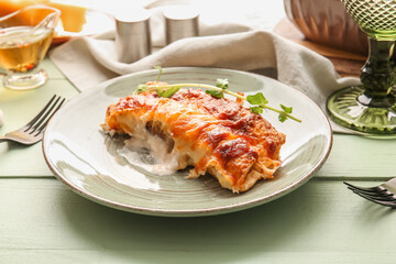 Plate with piece of delicious casserole with minced meat on color wooden table