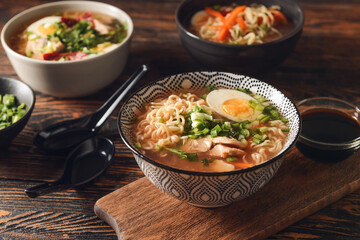 Tasty Chinese soup with chicken in bowls on wooden background