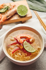 Bowl of tasty Thai soup with shrimps on table