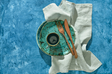 Clean tableware and napkin on color background