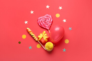 Composition with gift box, air balloon and sweets on color background