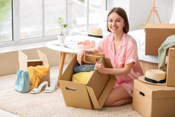 Young woman organizing clothes in bedroom