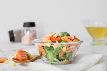 Bowl with different frozen vegetables on table