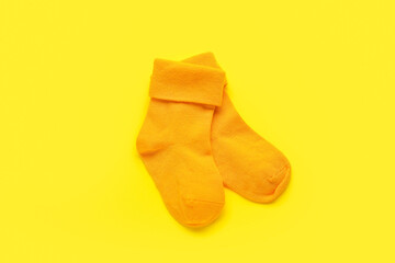 Baby socks on color background