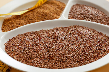 Bowl with flax seeds on table, closeup