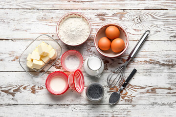 Ingredients for delicious muffins with poppy seeds on wooden background