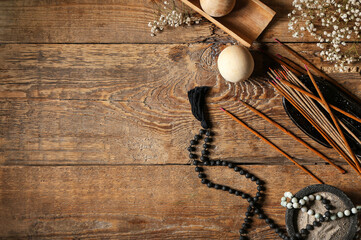 Composition with incense sticks and Tibetan beads on wooden background