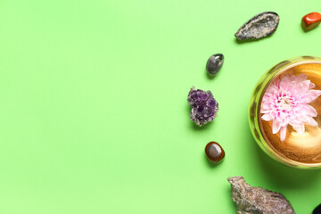 Tibetan singing bowl and chakra stones on color background