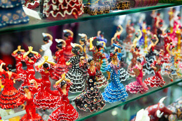 Ceramic mosaic and painted flamenco dancers figurines in colorful traditional dresses on showcase...