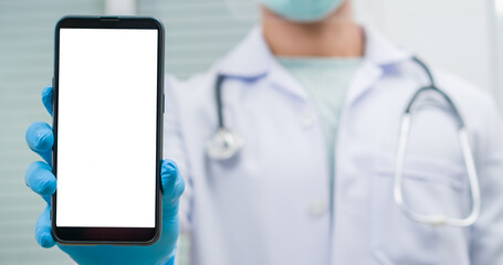 Doctor showing information on a smartphone. Healthcare technologies. Unrecognizable male doctor holding modern smartphone with blank screen, closeup