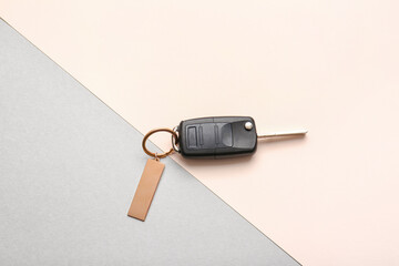 Car key with stylish keychain on color background